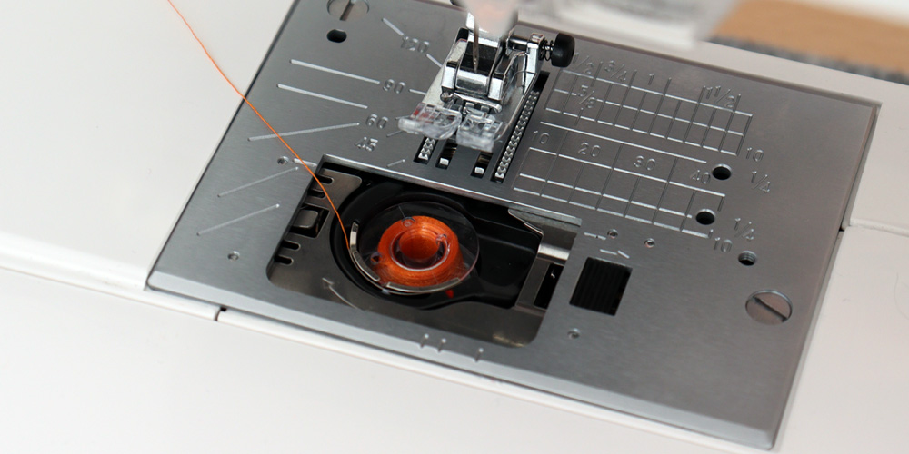 Oryginalna szpulka Janome w bębenku maszyny do szycia.